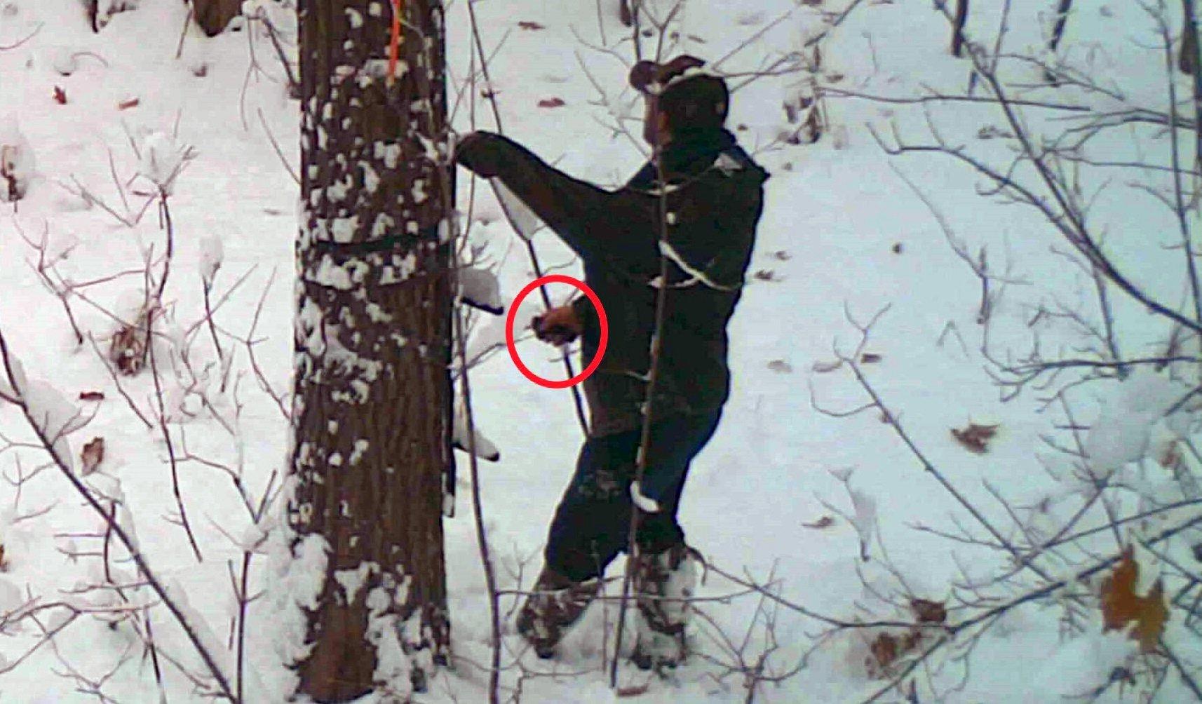 Footage from a trail camera shows Thomas Steele III, 23, intentionally cutting the straps on a hunter's treestand. Image by Michigan Department of Natural Resources