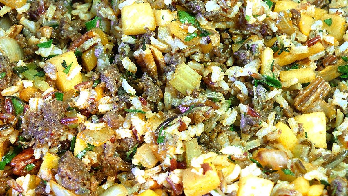 Blend wild rice, diced apples, sausage, pecans and other ingredients to make the stuffing.