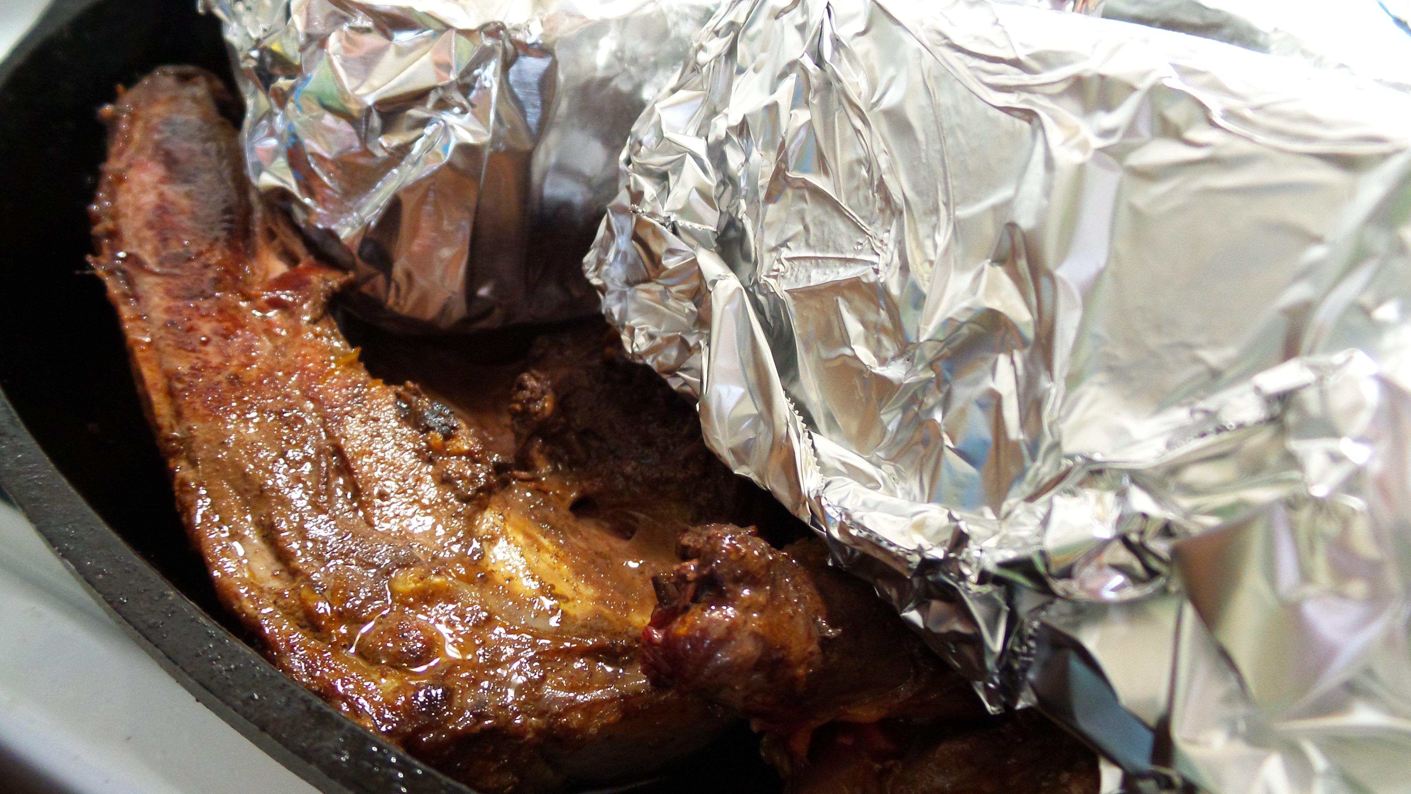 Foil wrapped bricks press the duck's skin tightly against the iron skillet for a perfect sear. 