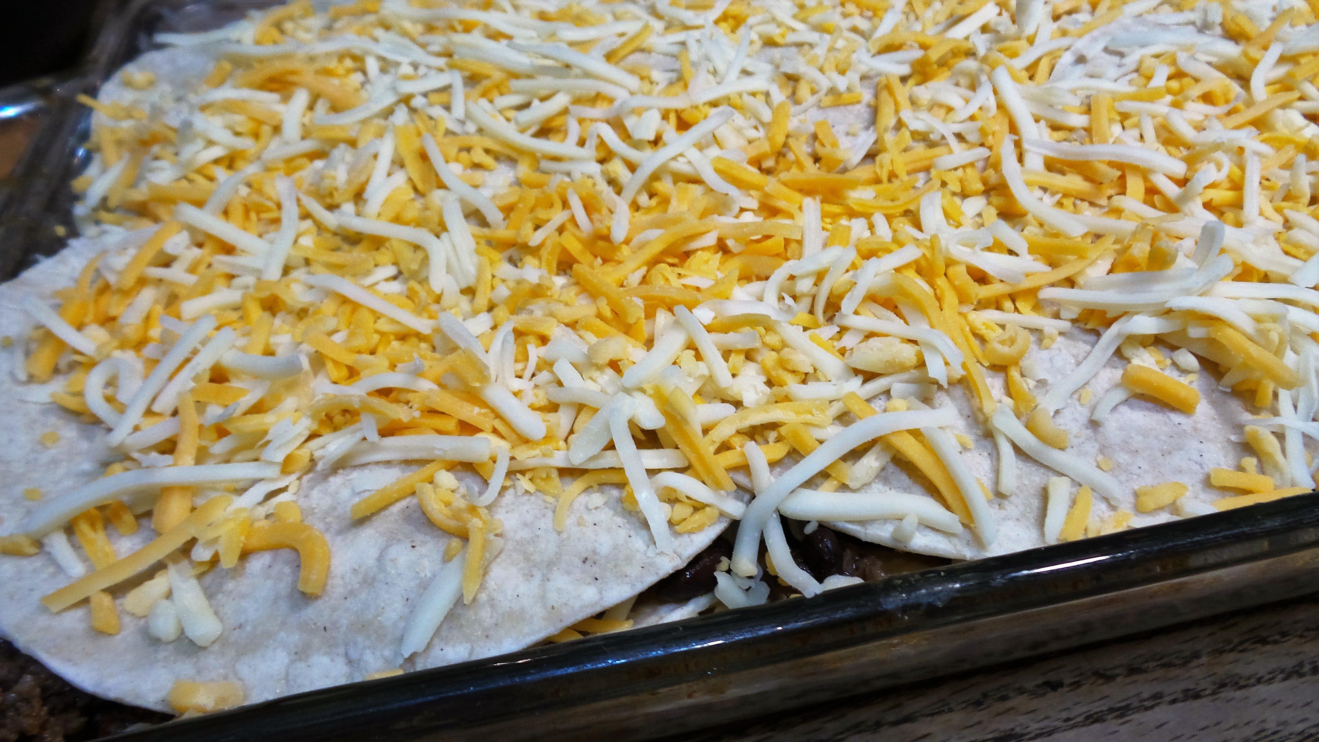 Layer tortillas, meat and cheese till dish is full. Finish with cheese.