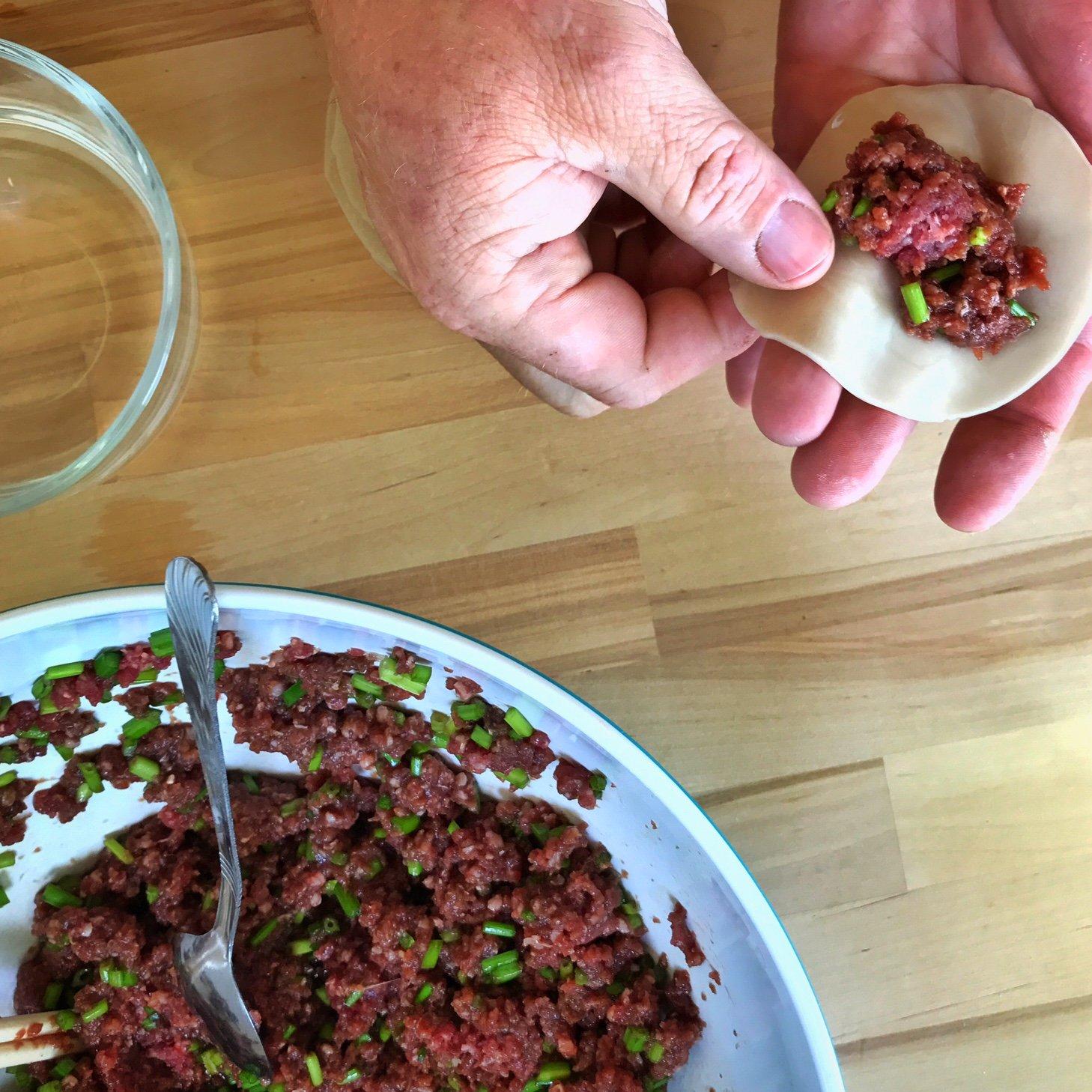 A venison steamed dumpling takes form in front of the camera.