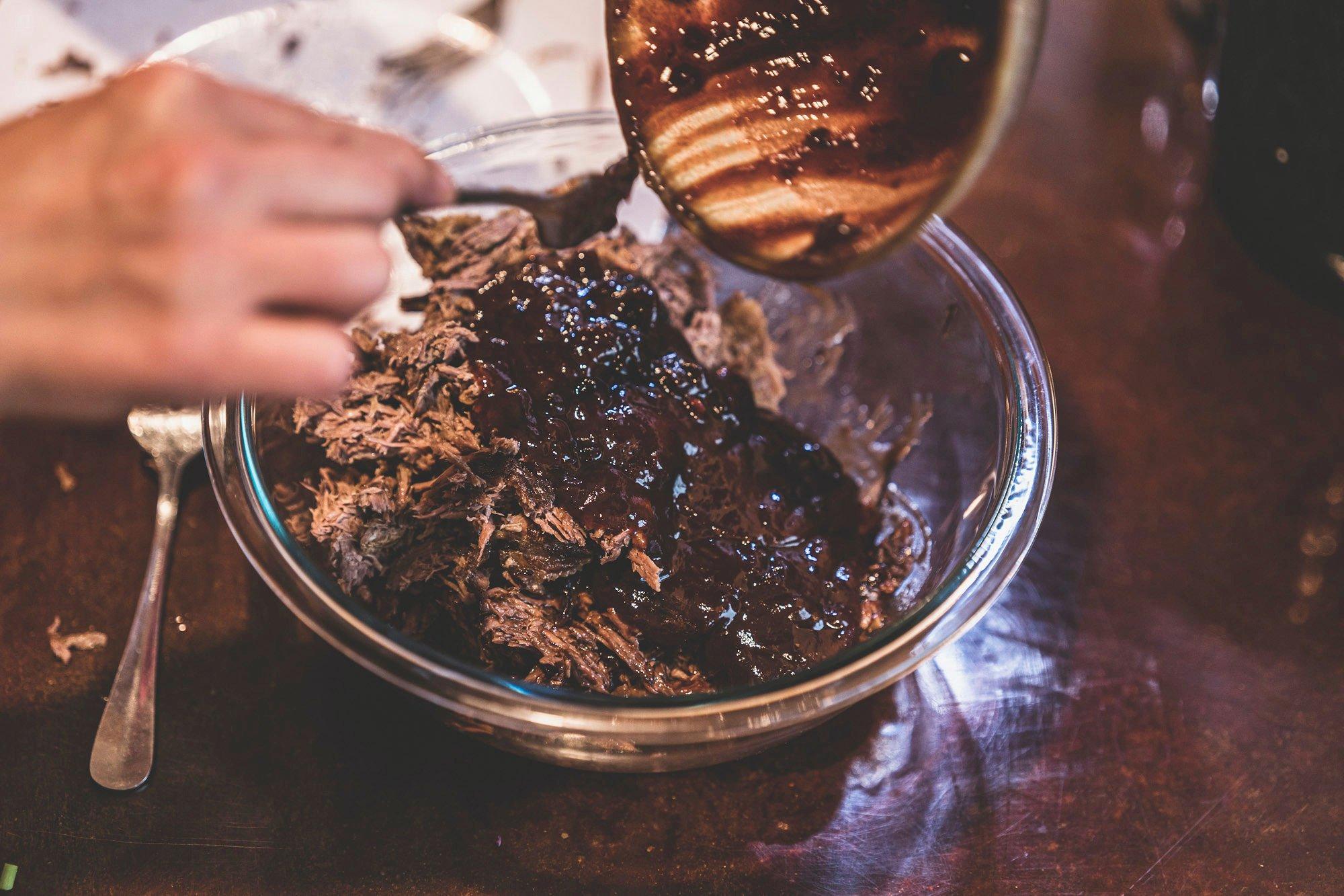 Add the BBQ sauce to the braised meat. Image by Grit Media