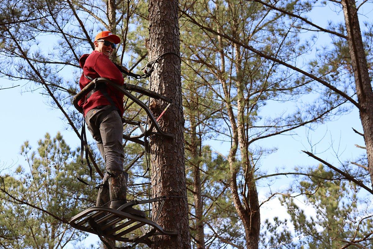 Graduate student Kevin Ostrander uses a climbing stand to mount listening units. Photo by Dr. Will Gulsby