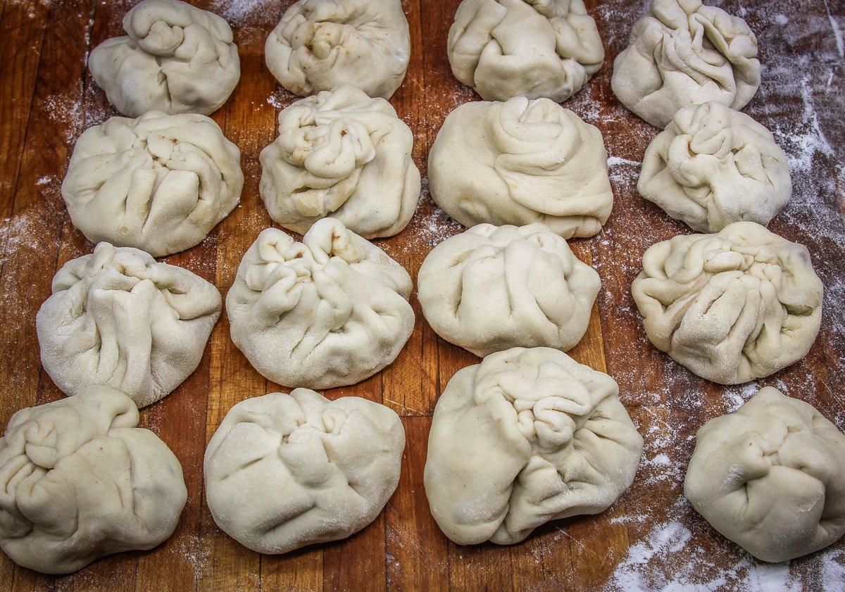 Fold and crimp the dough around the filling to seal the buns.