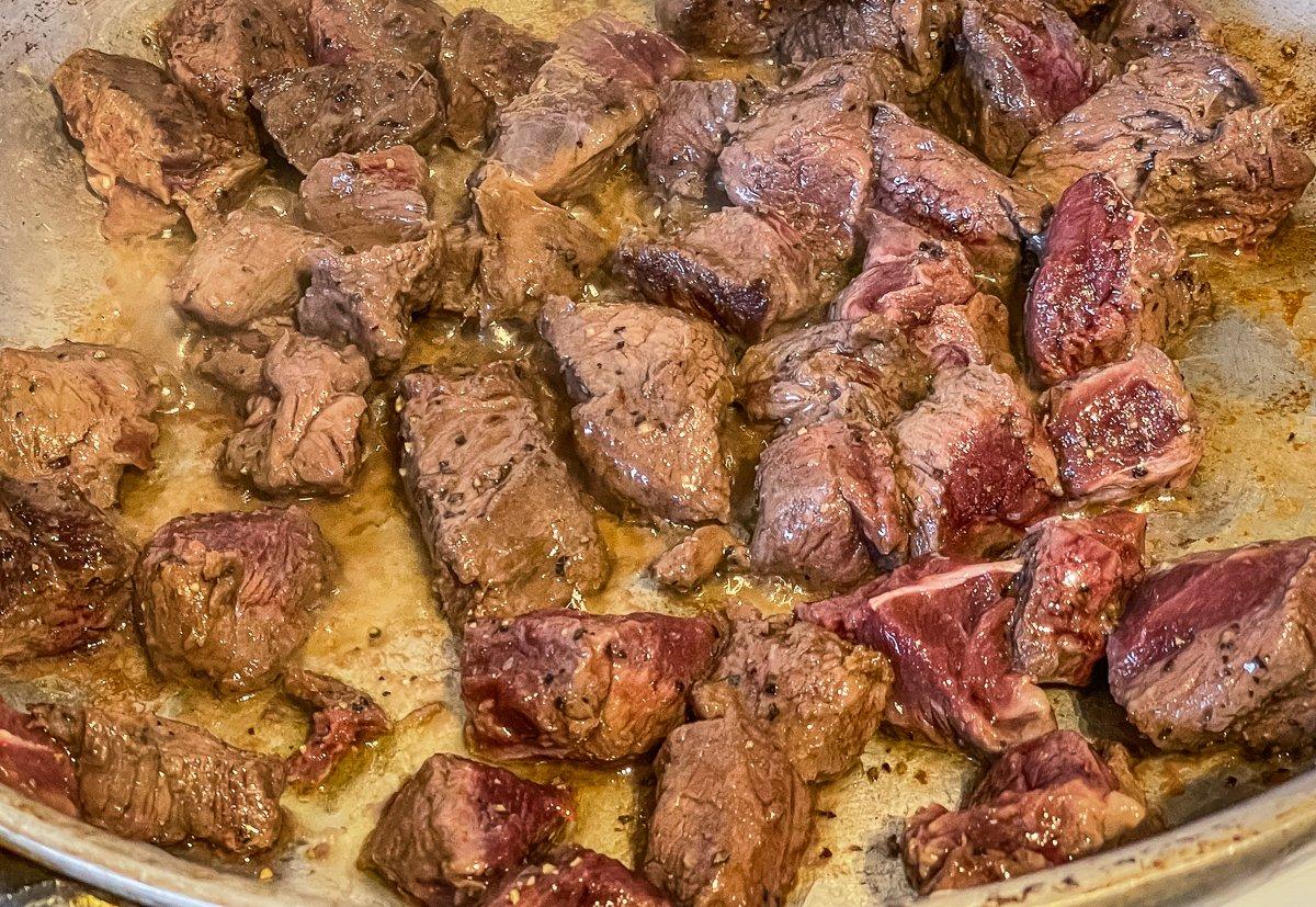 Brown the venison in a skillet before adding to the slow cooker.