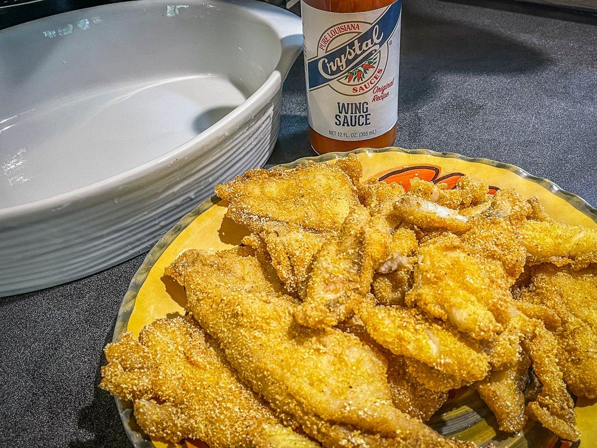 Drain the fried fish on a paper lined platter.