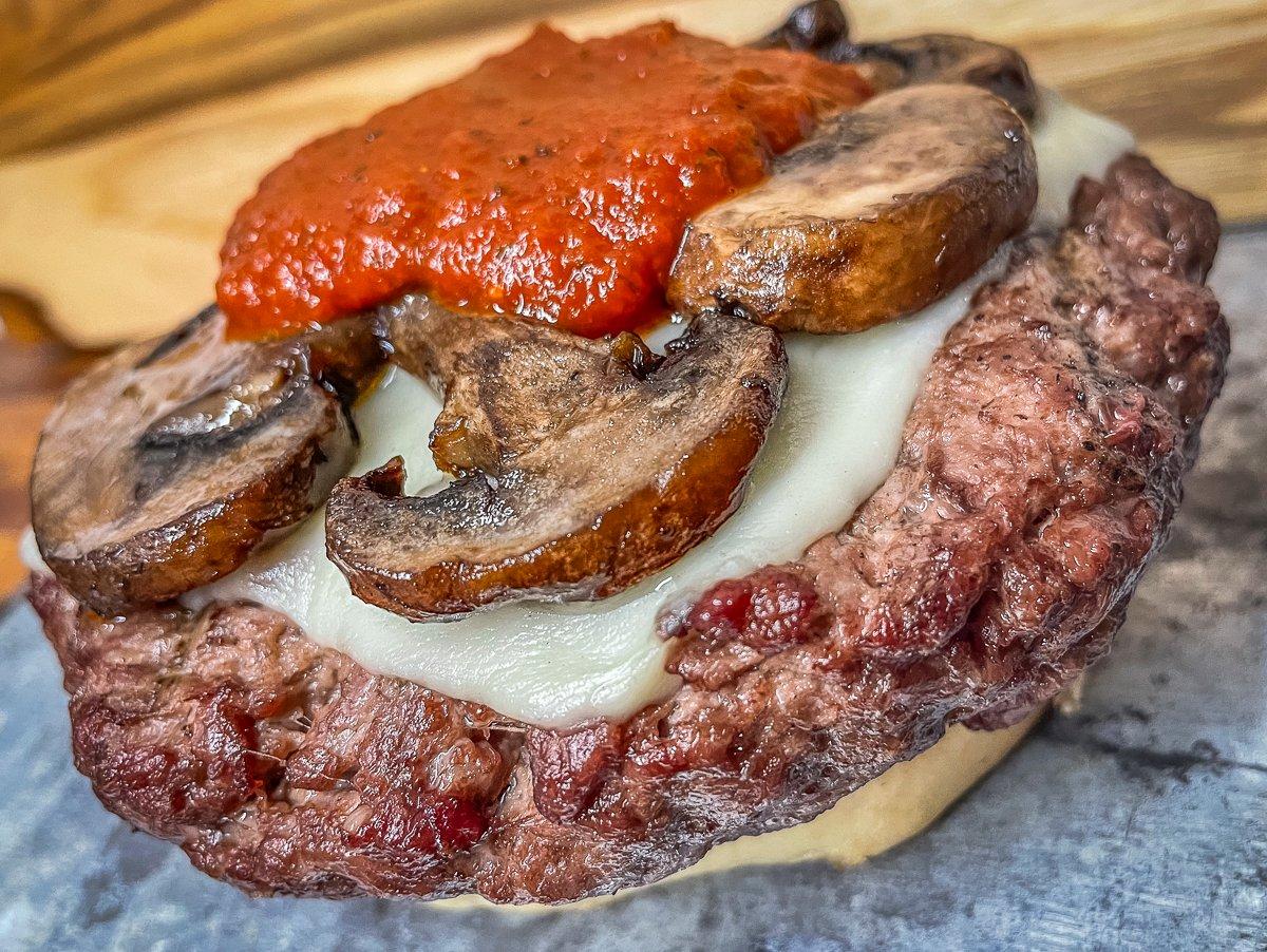 Top the burger with sautéed mushrooms and pizza sauce.