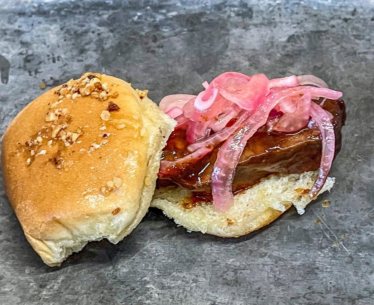 Sauce the sliced backstrap, then top with pickled onions.