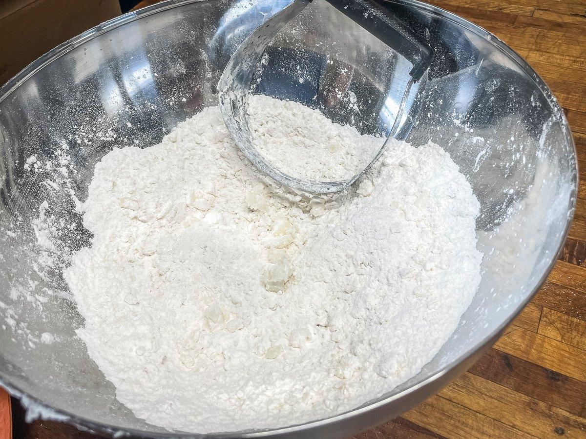 Use a pastry cutter or fork to cut the fat into the flour mixture.