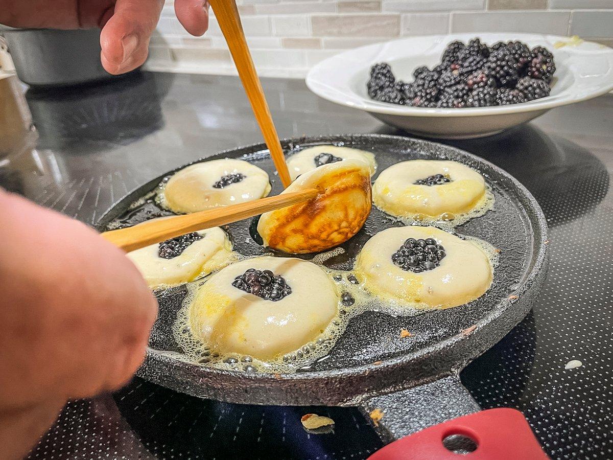 Use traditional wooden skewers, or a set of chopsticks, to flip the aebleskivers in the pan. 