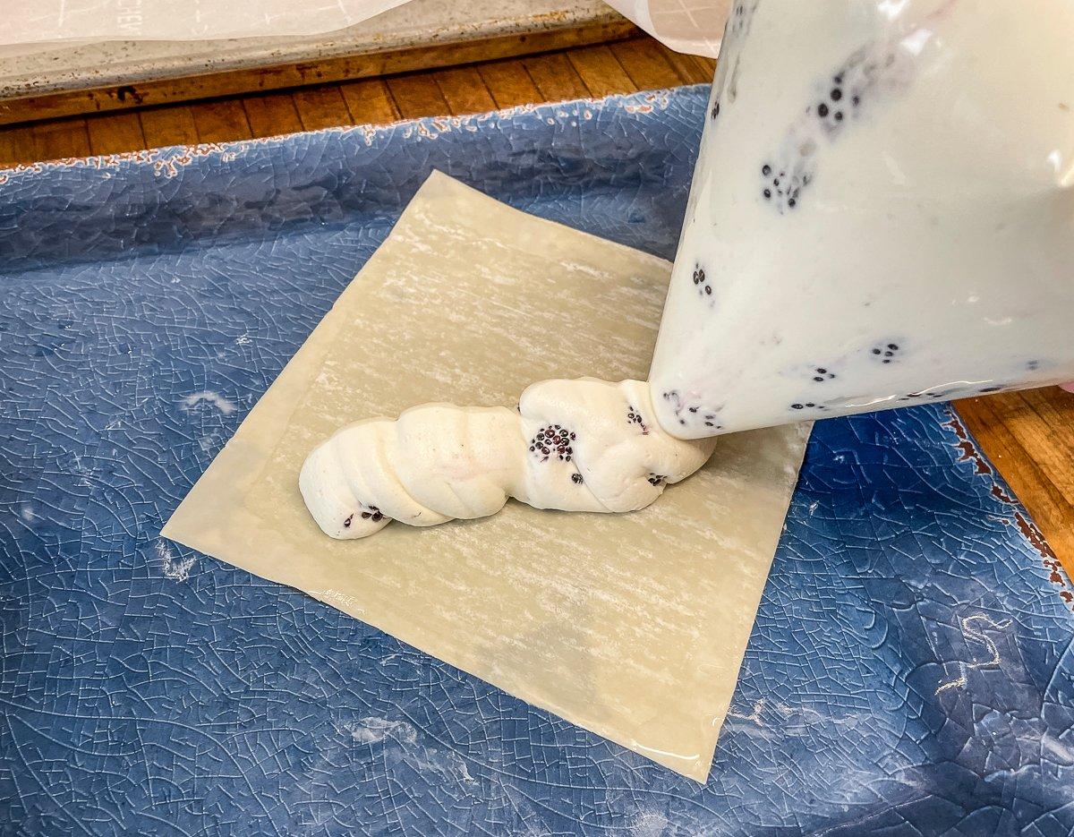 Pipe the filling onto the egg roll wrappers.