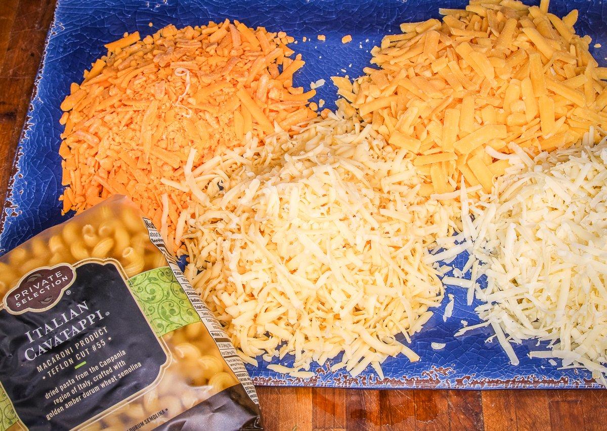 Grate all four cheeses and prepare the pasta according to package directions. 