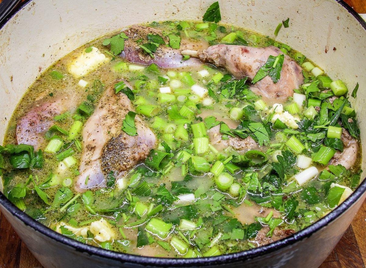 Add the fresh parsley and green onions to the pan, then cover and bake until tender. 