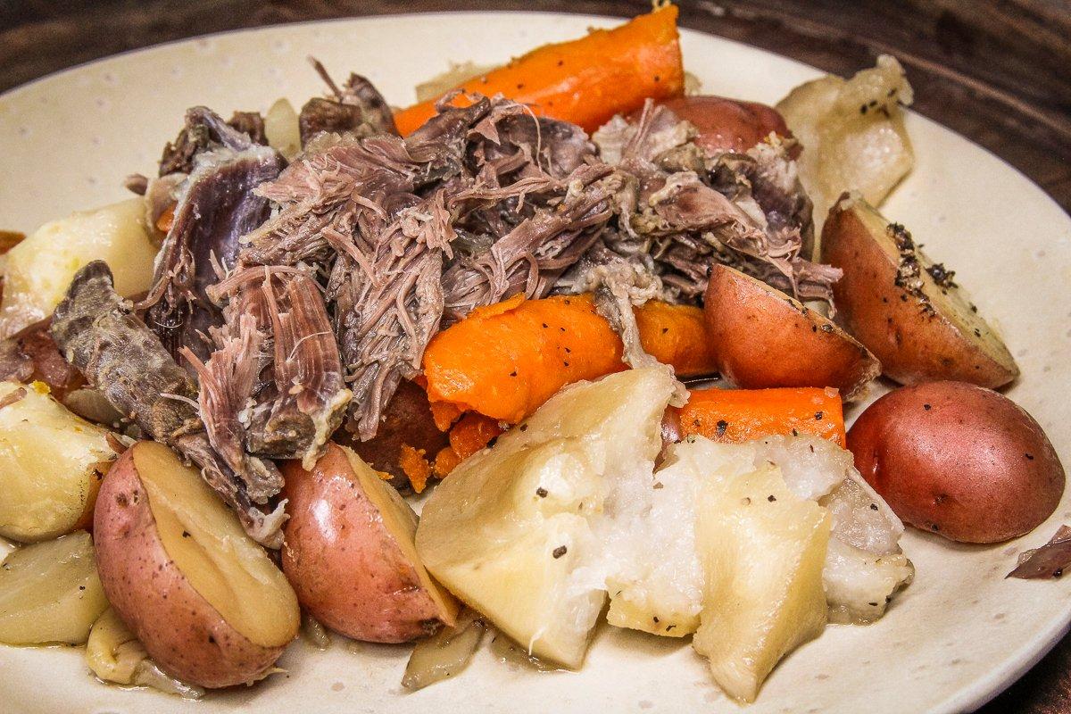 Slow roast the raccoon and root vegetables until the meat is tender and shreds easily from the bone.
