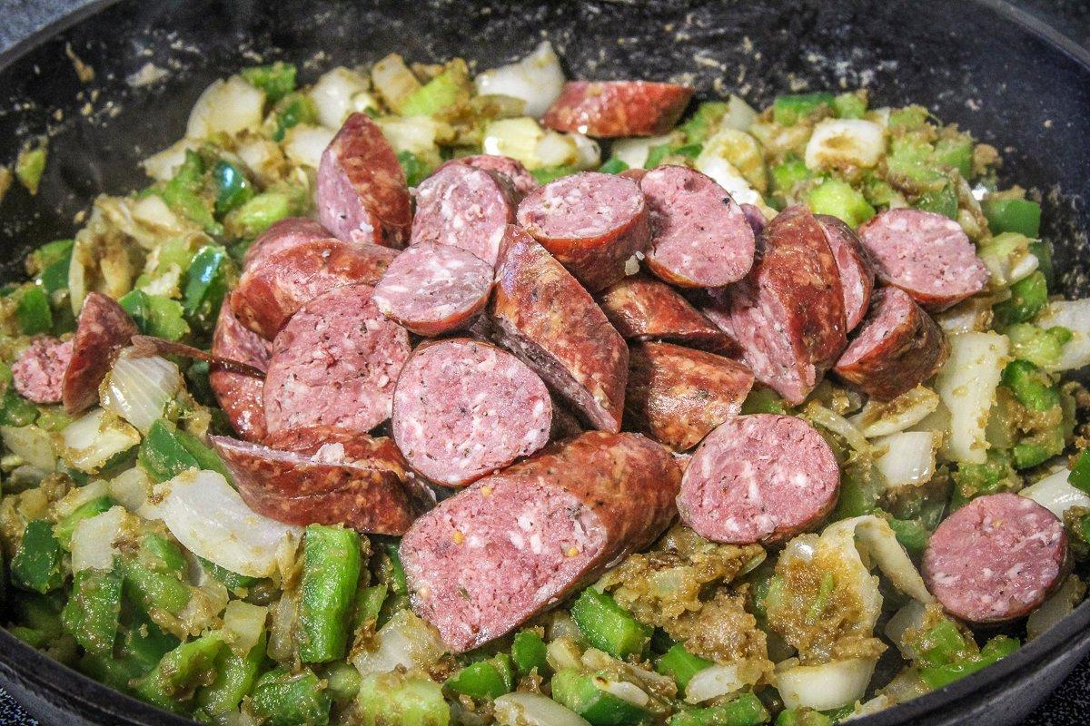 Cook the vegetables in the roux until they are soft, then add the sausage.