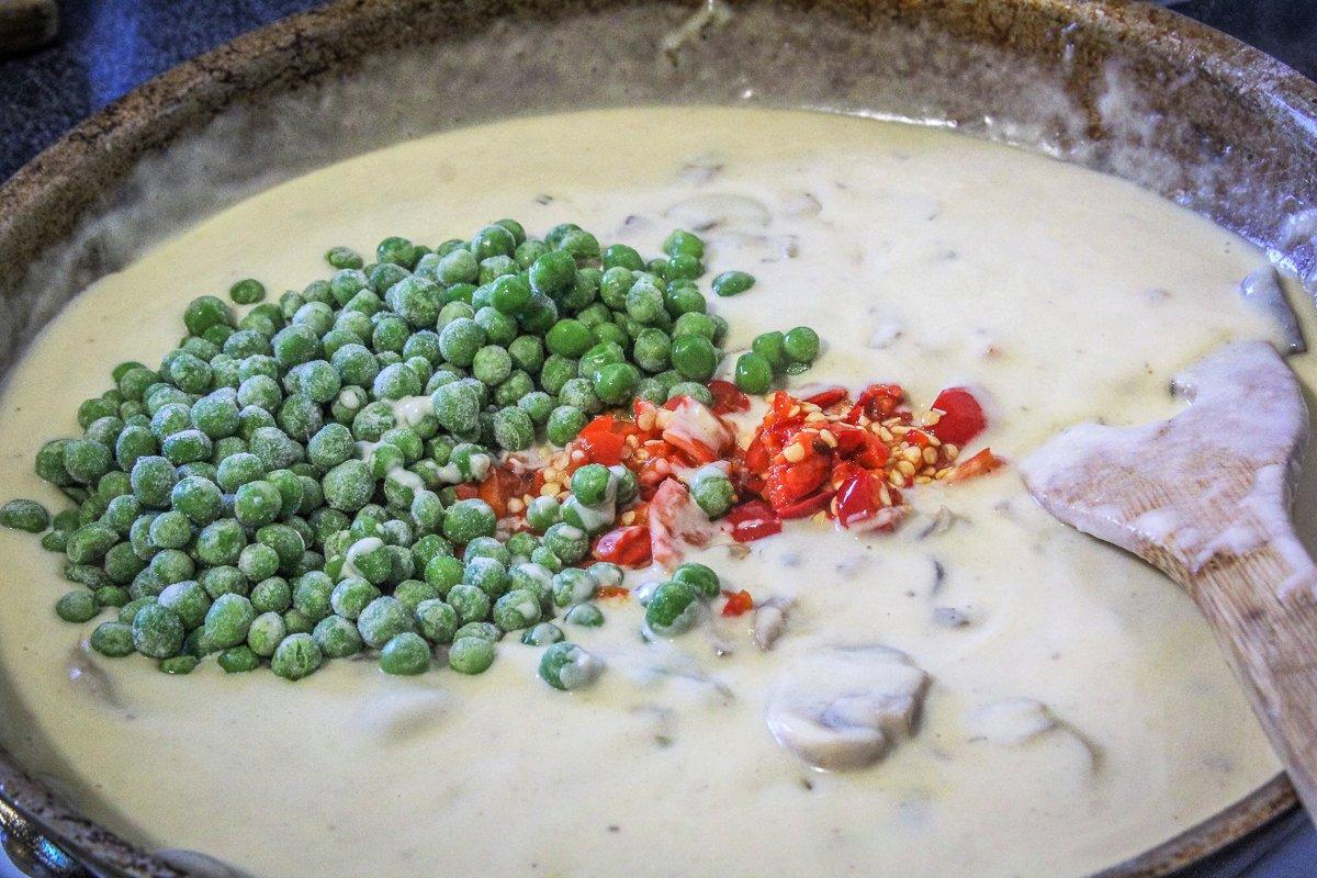 Stir the frozen peas and diced peppers into the mushroom cream sauce.