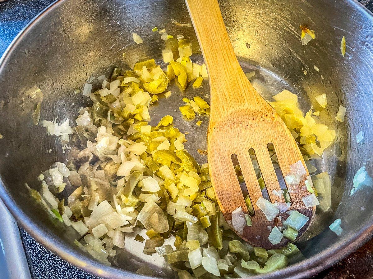 Start the sauce by sautéing the onions and jalapeños. 