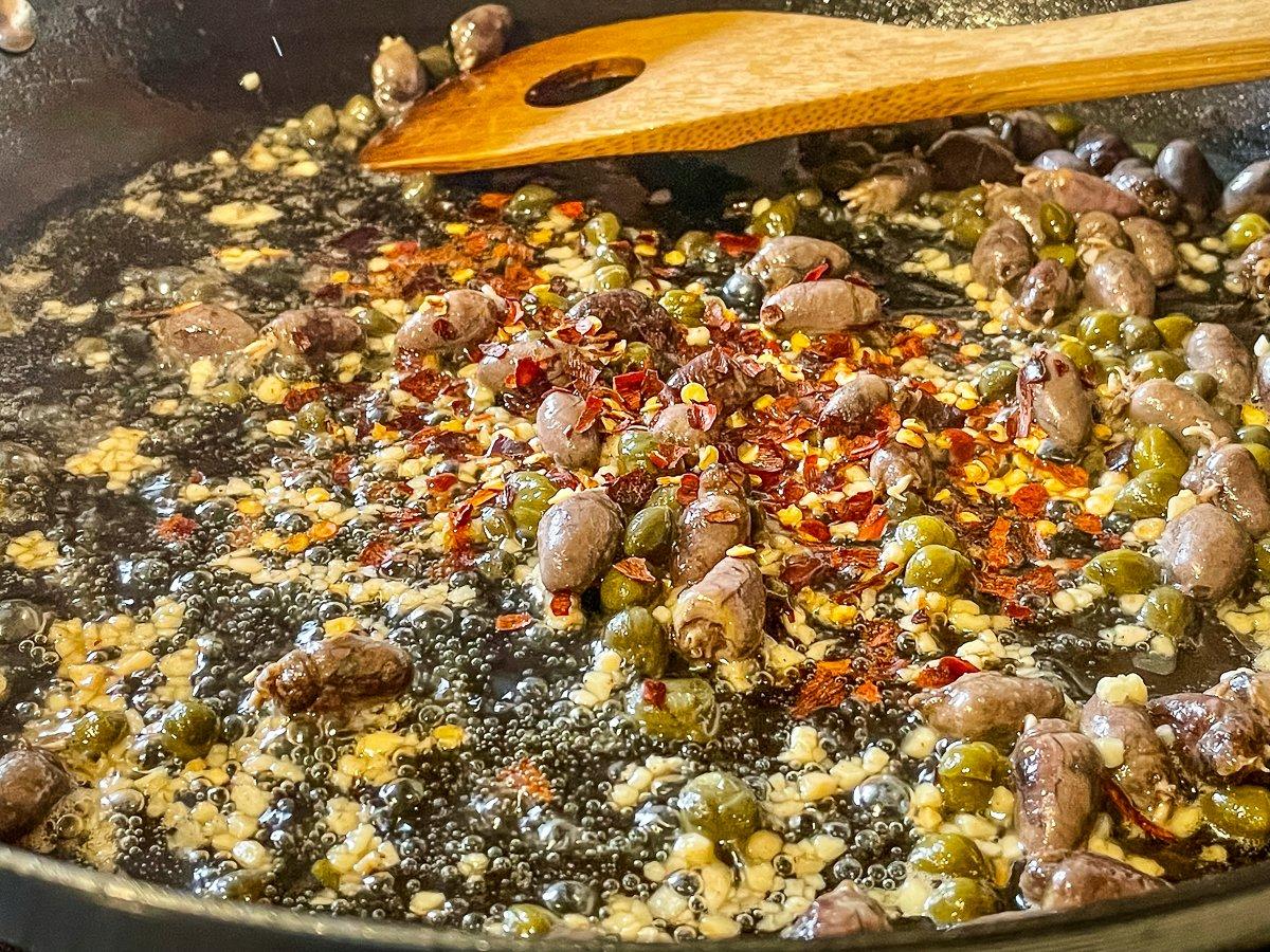 Sauté the hearts then add the chili flakes, garlic and capers.