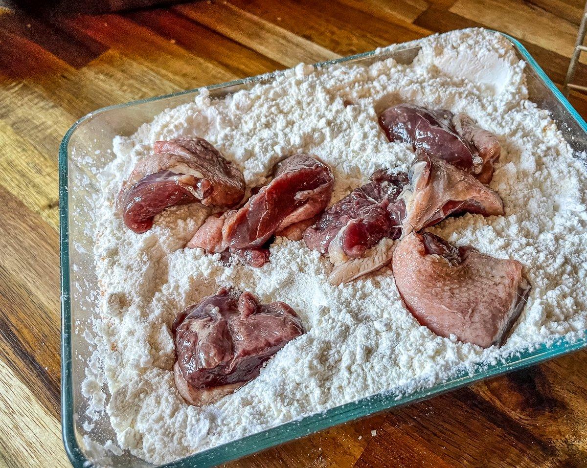 Start by dusting the duck breast in seasoned flour.