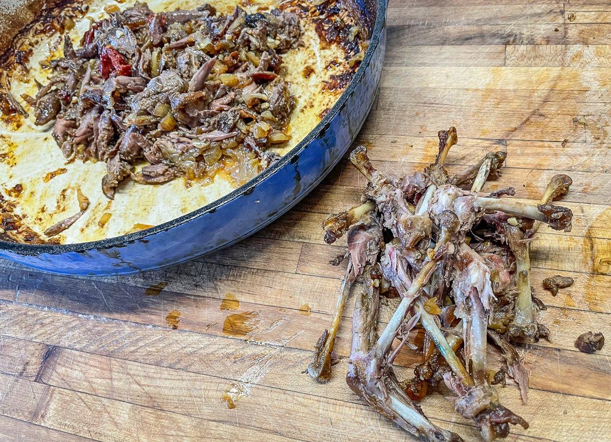 Pick the meat from the bones and return it to the pan.