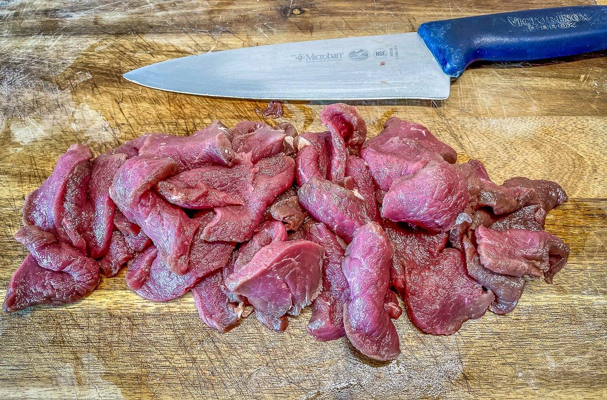 Slice the elk backstrap across the grain into thin strips.