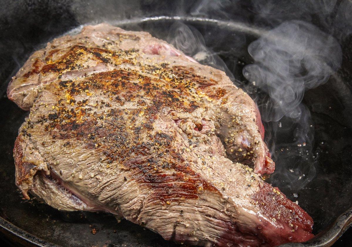 Sear the roast in a hot skillet until well browned on all surfaces.