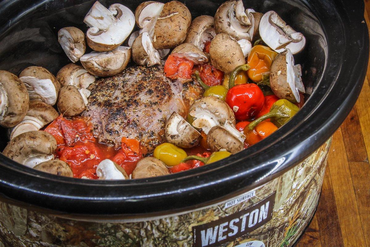 Load the roast and other ingredients into the slow cooker.