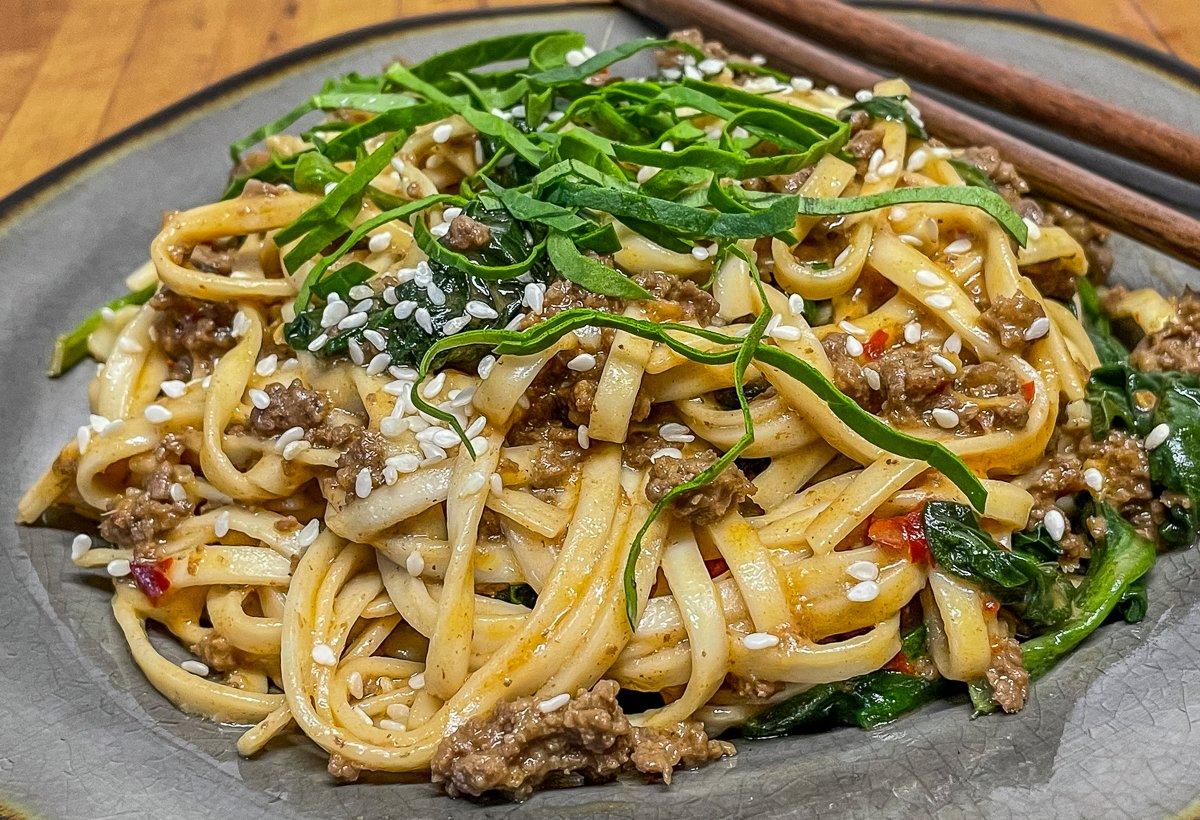 Stir in the noodles before serving. Garnish with sesame seeds and fresh spinach.