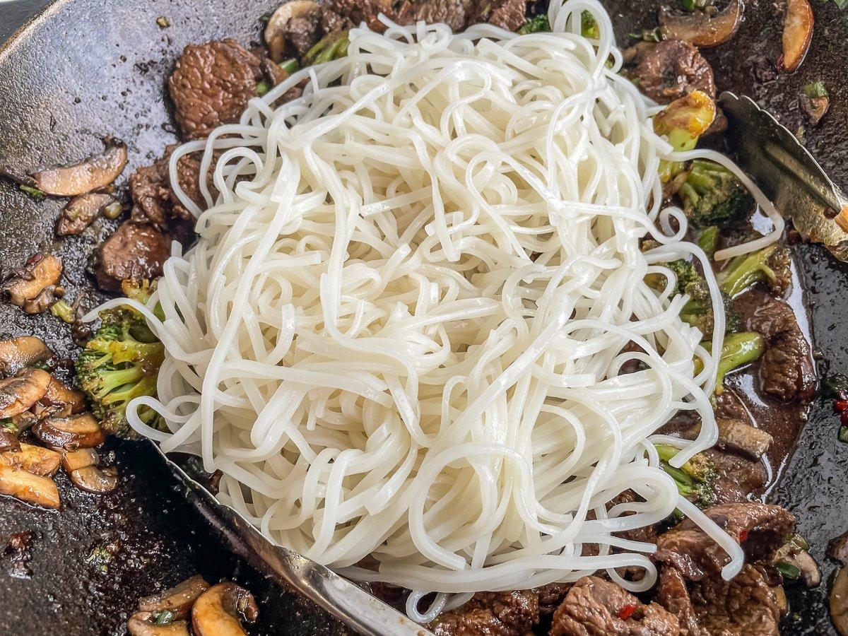 Add the cooked noodles to the stir fry and toss with the sauce.