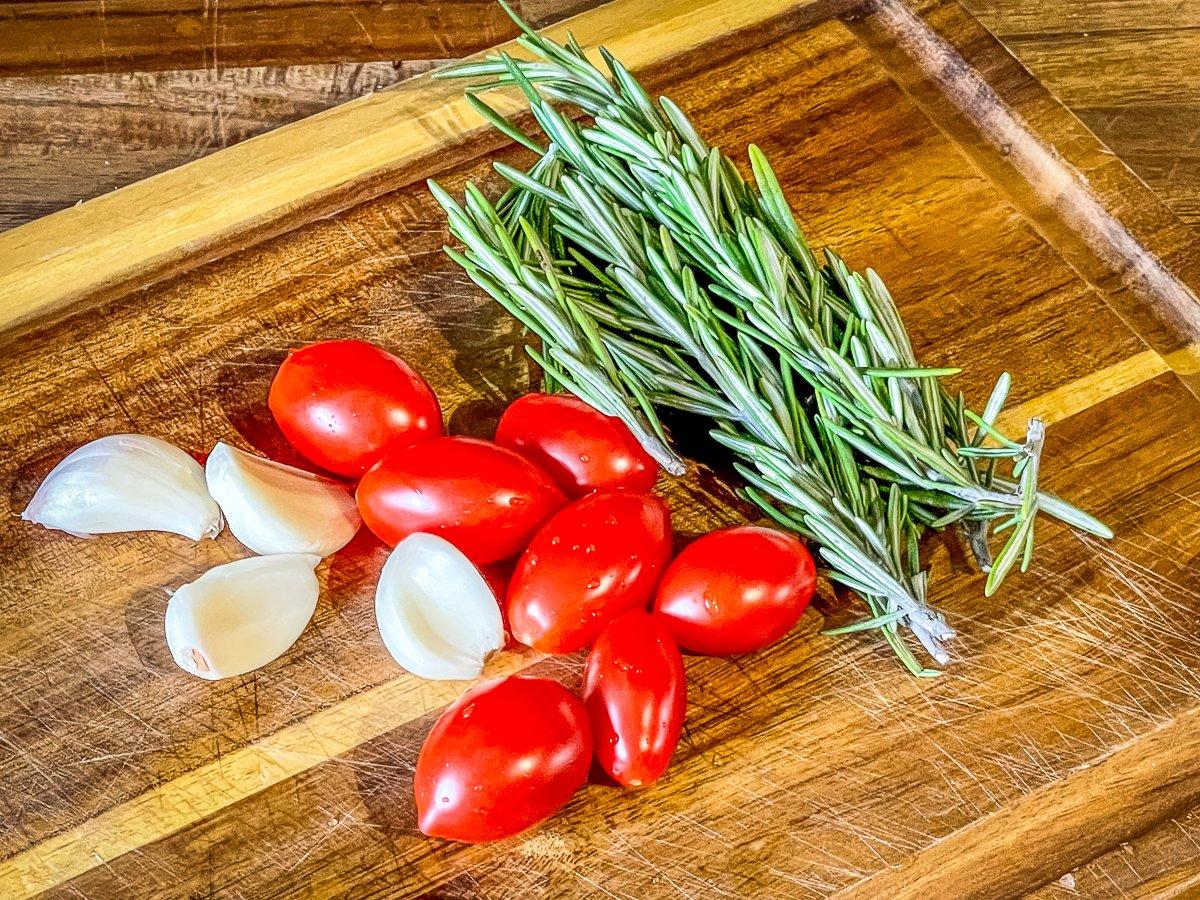 Top with garlic, fresh rosemary and sliced tomatoes.