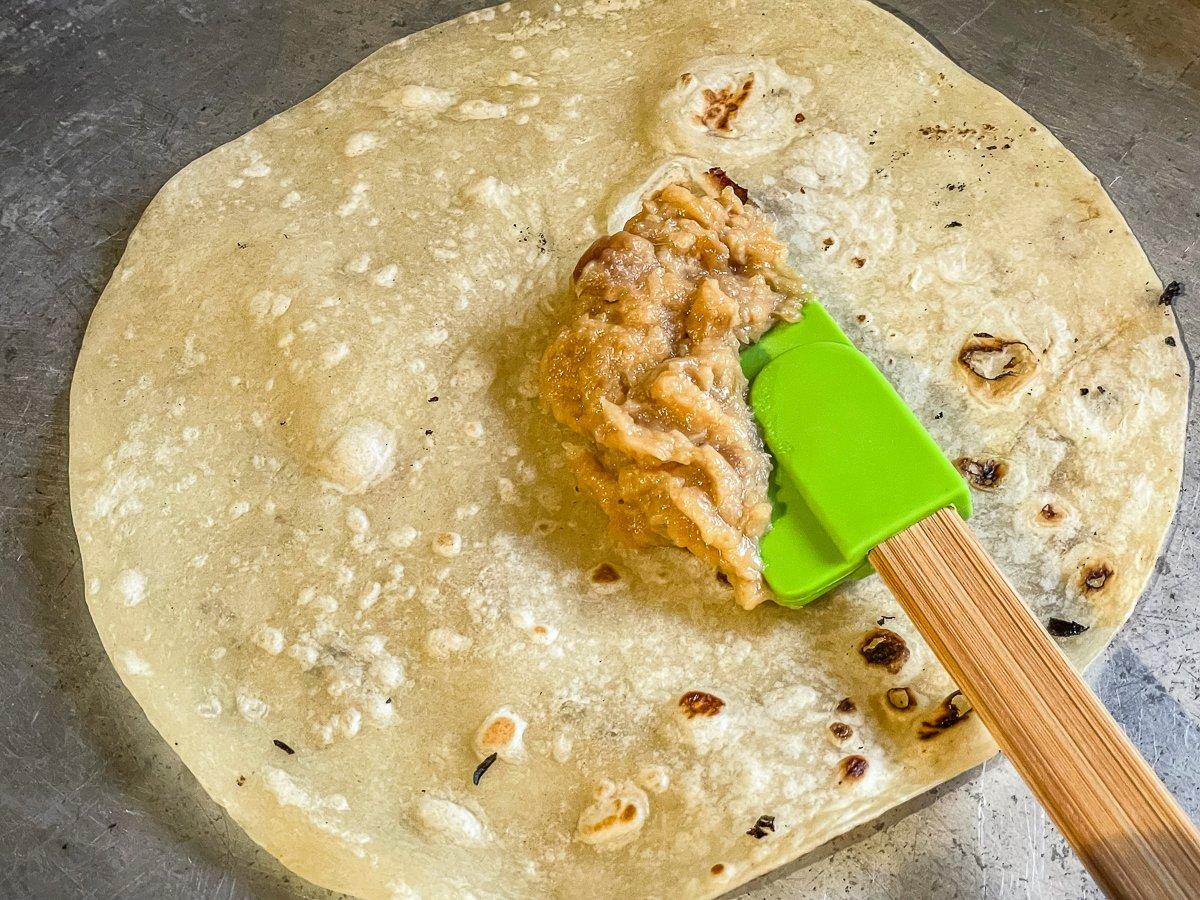 Spread a thin layer of roasted garlic over the tortilla.