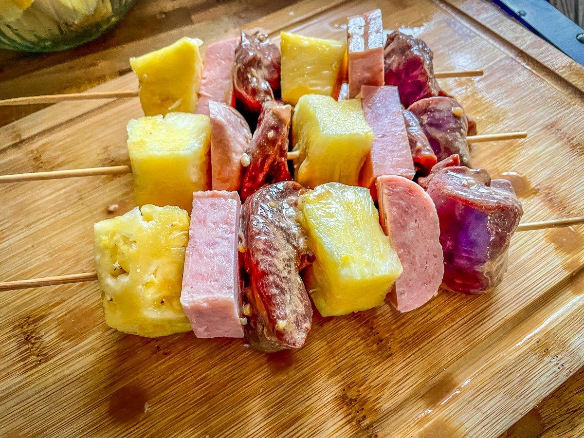 Alternate the marinated goose, pineapple, and Spam on bamboo skewers.