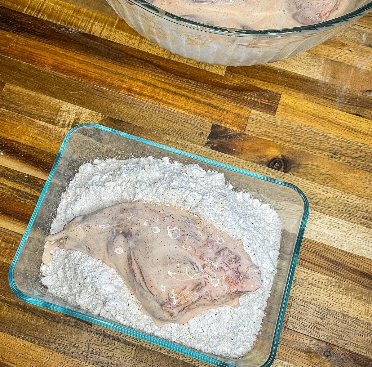 Dredge the marinated rabbit in seasoned flour.