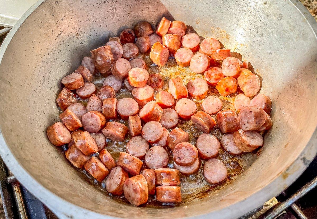 Brown the sausage in a large pot before adding the vegetables.