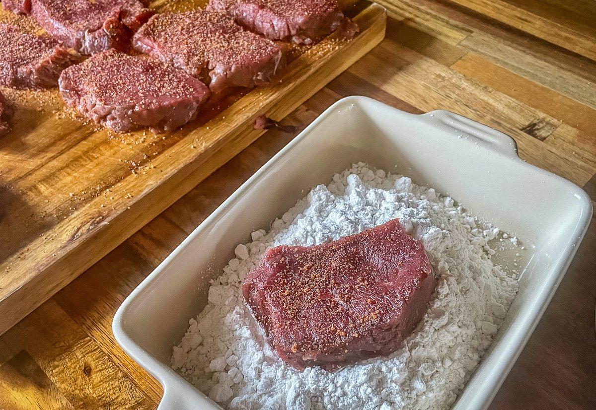 Season the backstrap and dredge on both sides with the flour mixture.