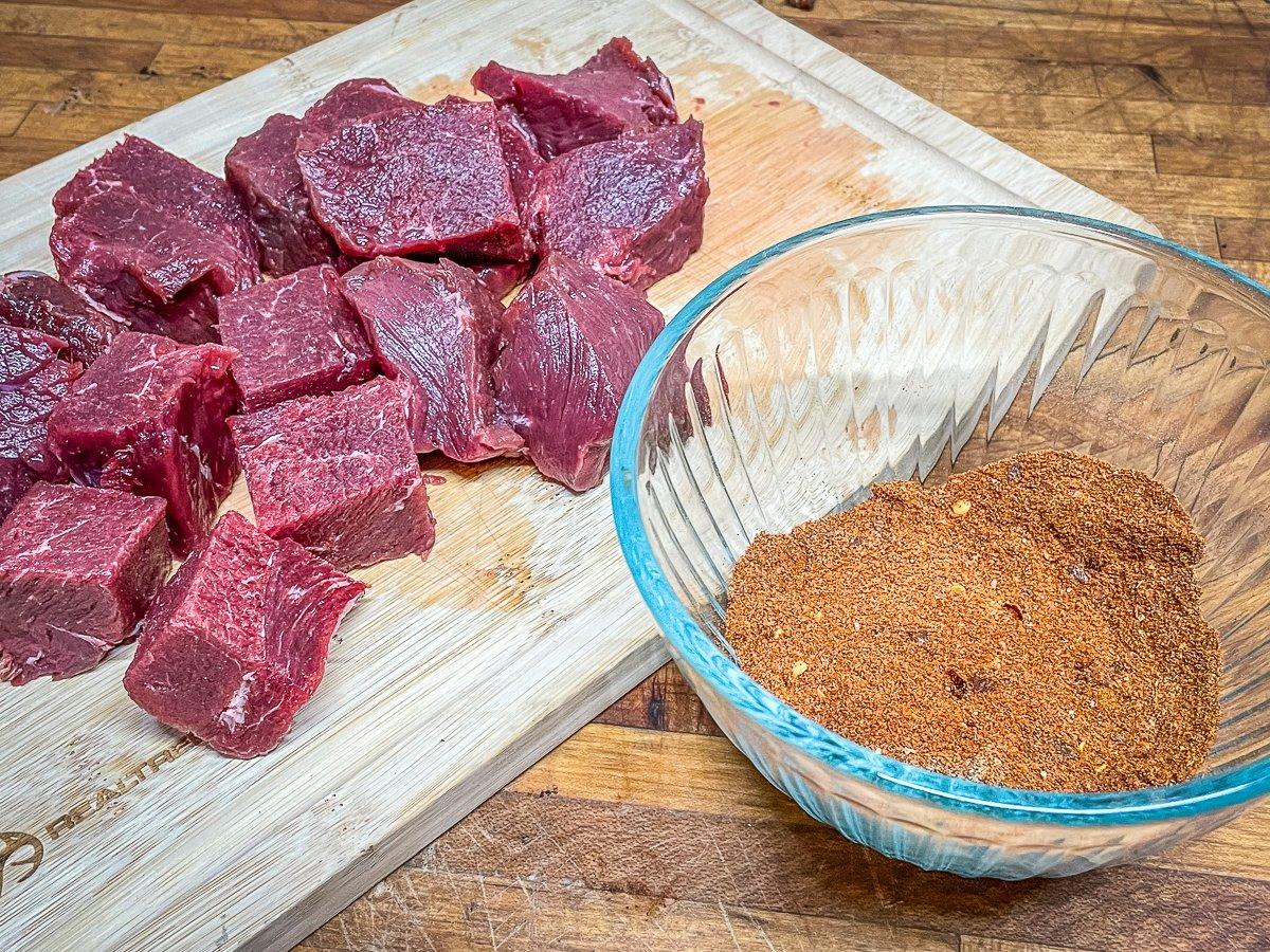 Start by mixing the spice blend and cutting venison backstrap into 1.5