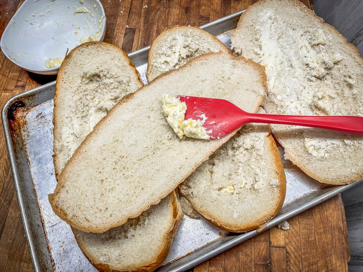Spread the softened garlic butter over the bread, then toast.