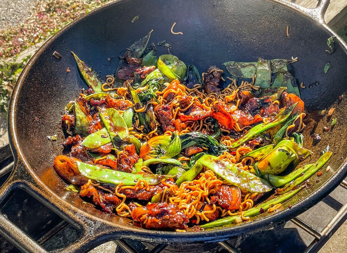 Add the cooked noodles to the wok and stir to combine and coat with sauce.