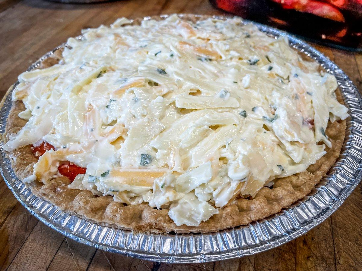 Spread the topping mixture over the sliced tomatoes.