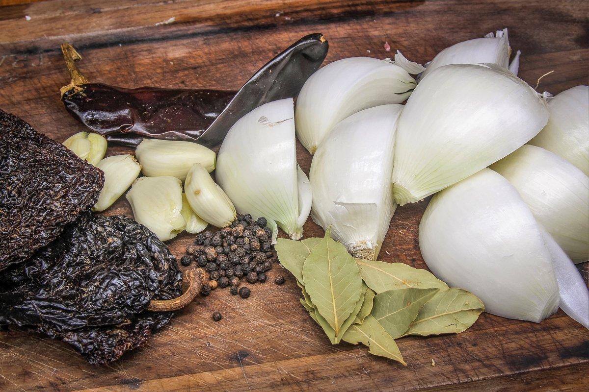 Simmer the tongues with aromatics like onions, dried peppers, garlic, and bay leaves.