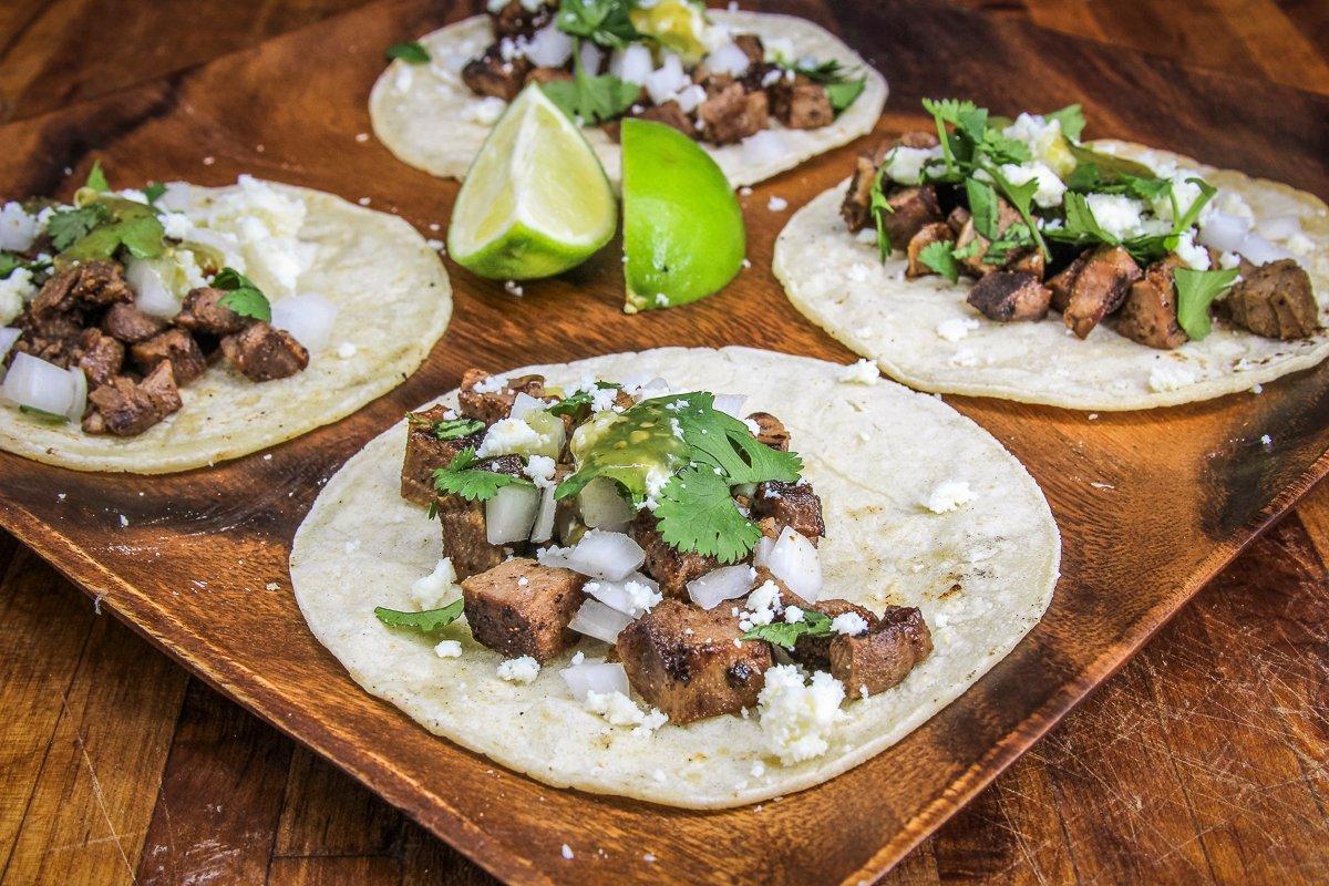 Serve the tongue on tortillas with traditional street taco toppings.