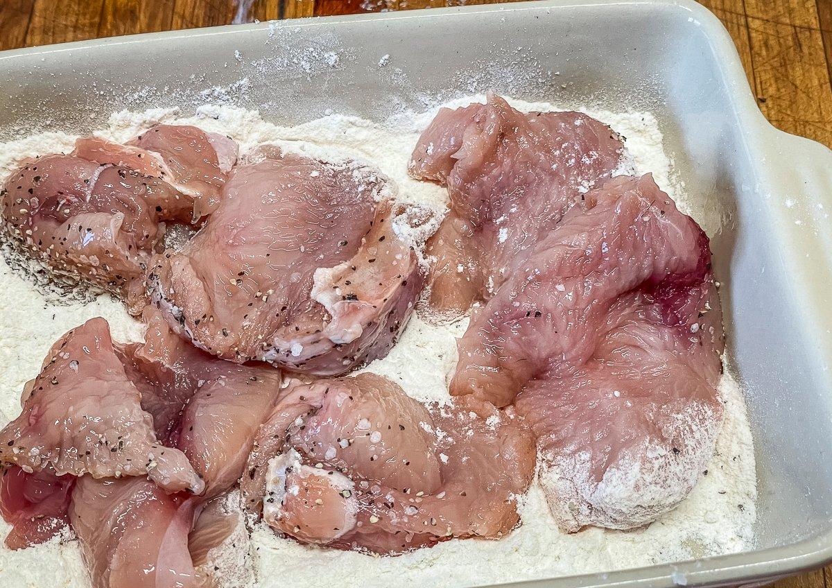 Dredge the turkey to coat with seasoned flour.