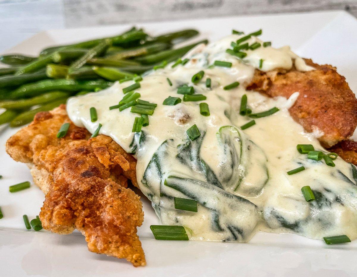 Spoon the sauce over the fried turkey and top with diced chives for garnish.