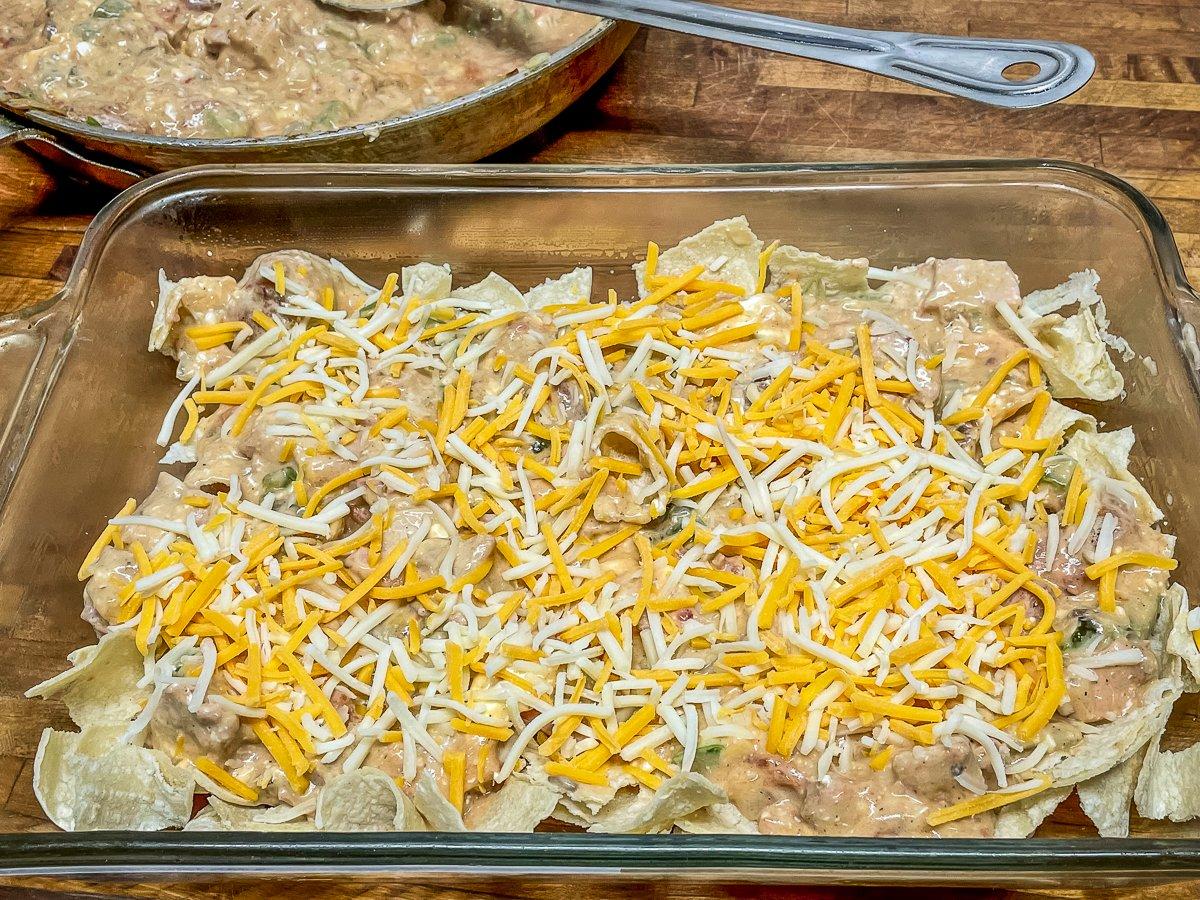 Layer the filling, cheese, and tortilla pieces until the pan is full.