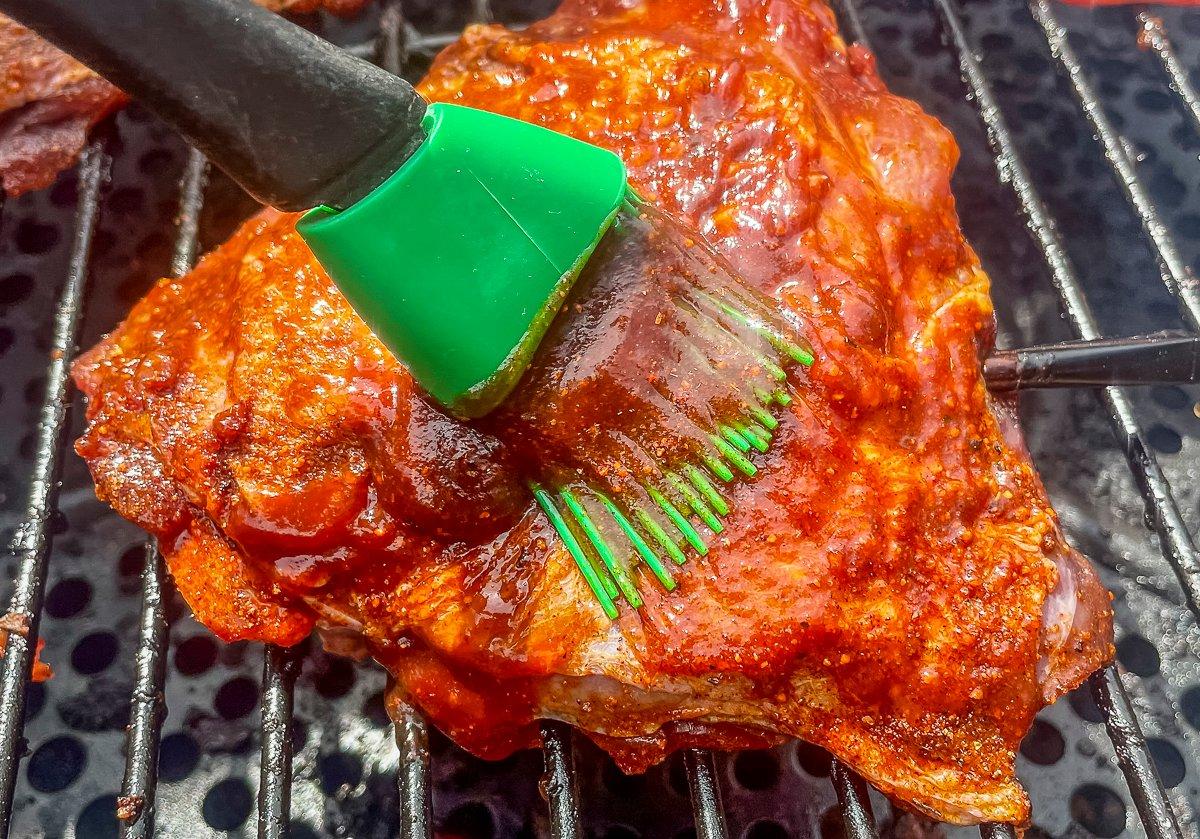 Brush on your favorite BBQ sauce as the thighs smoke.