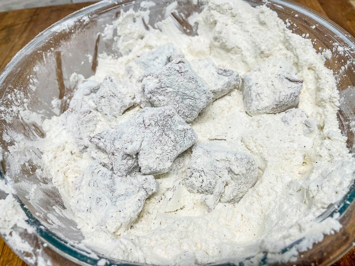 Toss the backstrap in the seasoned flour-cornstarch mixture.