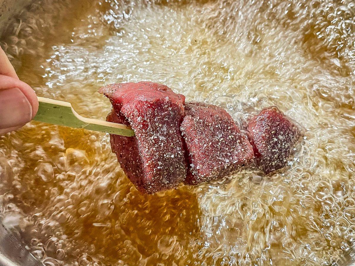 Drop the seasoned venison a few pieces at a time into the 350-degree oil.