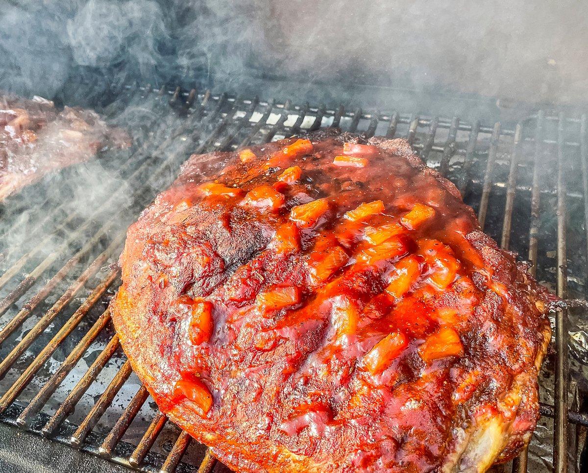 After pulling the ribs from the foil, brush on more sauce and continue cooking directly on the grate to set the sauce.