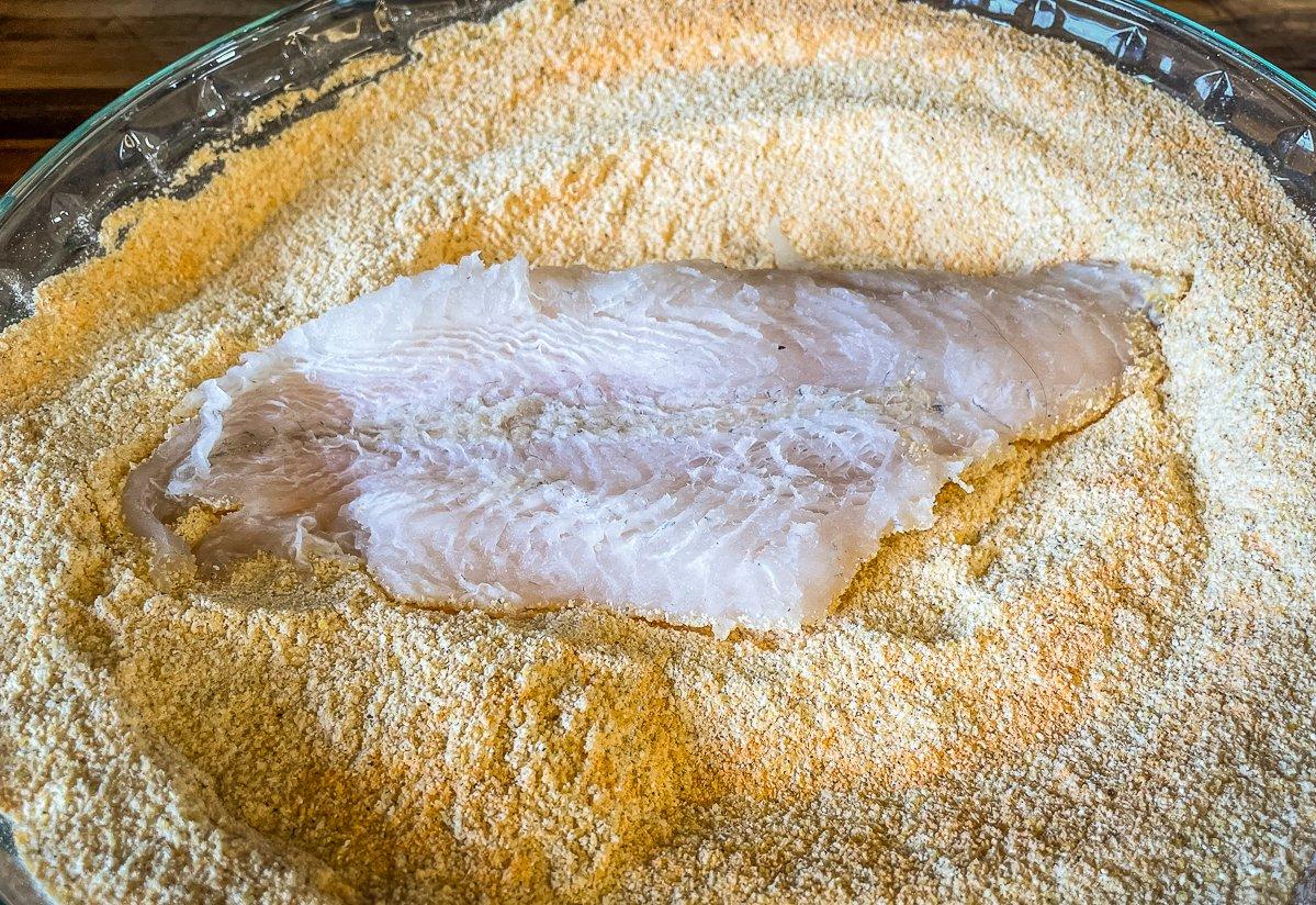 Dredge the catfish in seasoned cornmeal.
