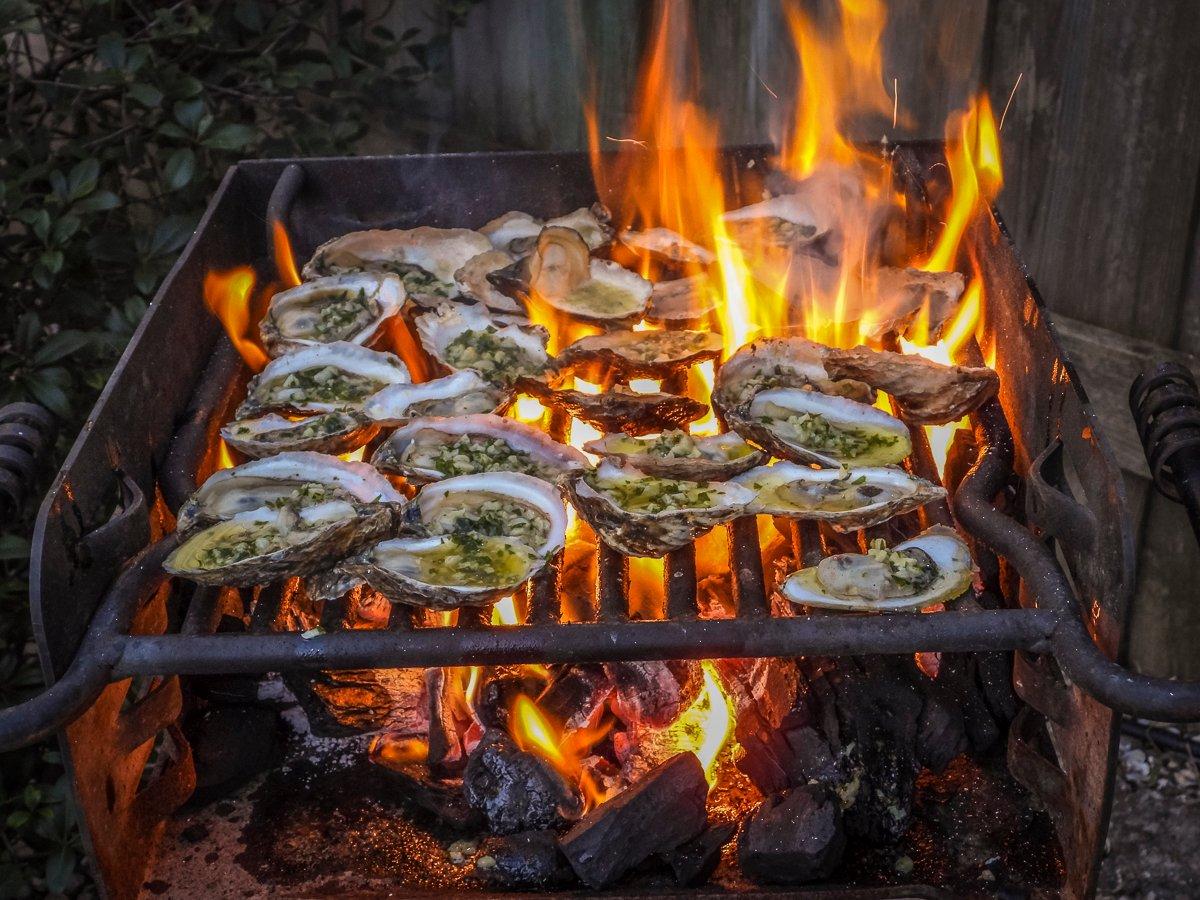 Spoon on the garlic butter, allowing the excess to flame up around the oysters.